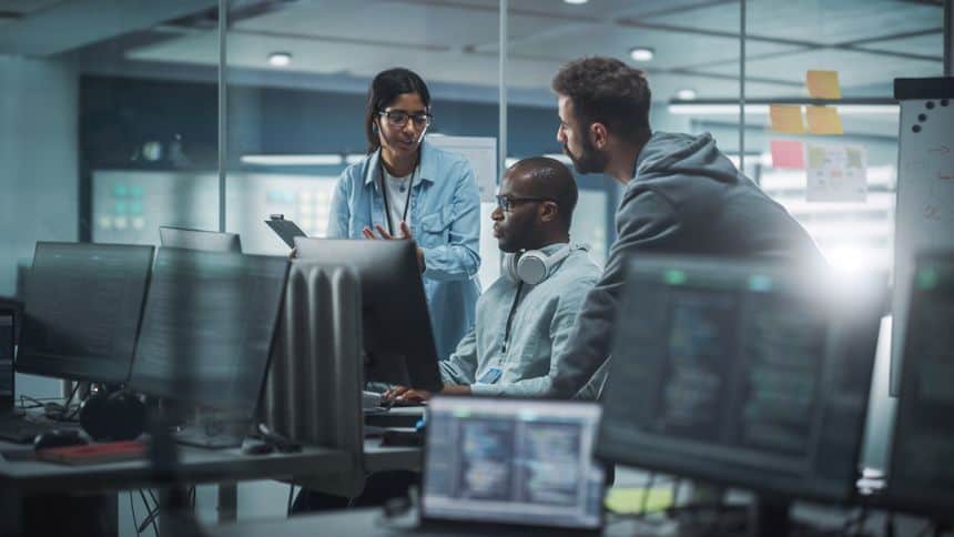 3 people in front of a computer monitor.